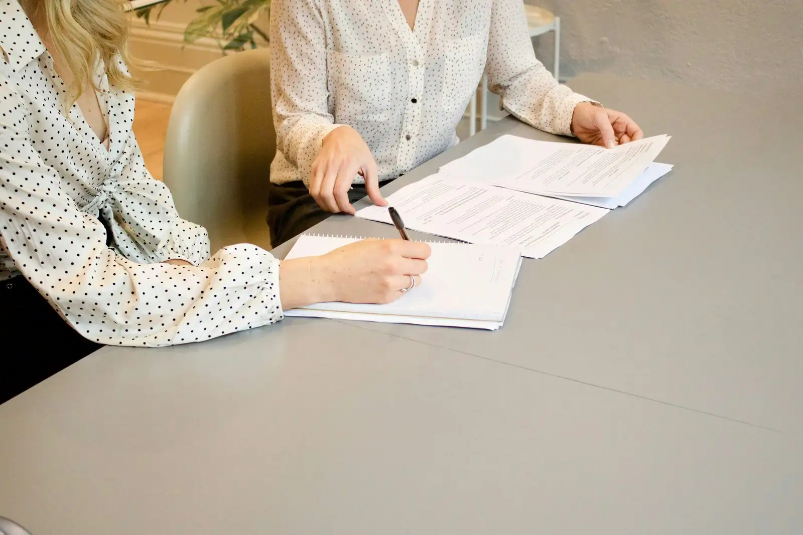 Two people working through a set of development application documents at a desk