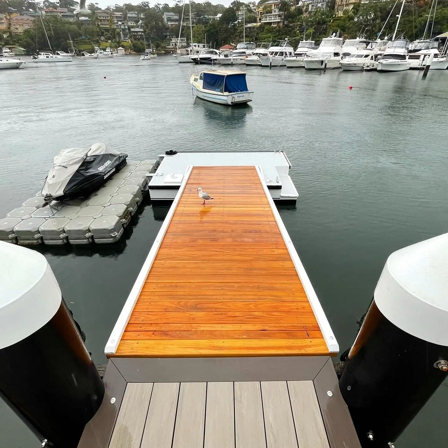 Modular floating dock with a jet ski berthed on it, off the end of a jetty