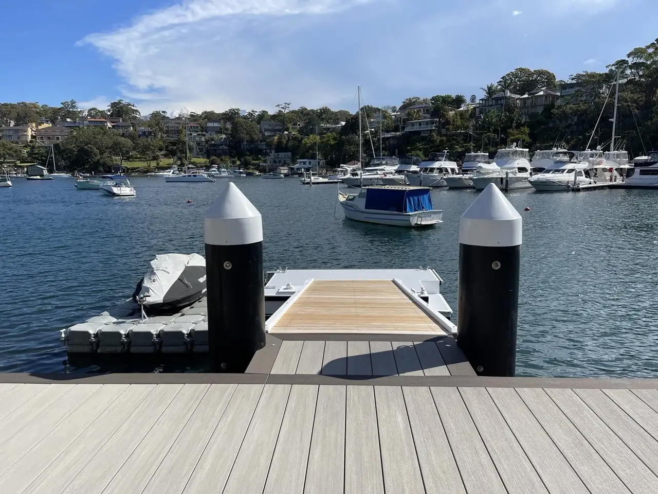 Jetty running out between two capped piles to a modular dock with a boat and jet ski alongside
