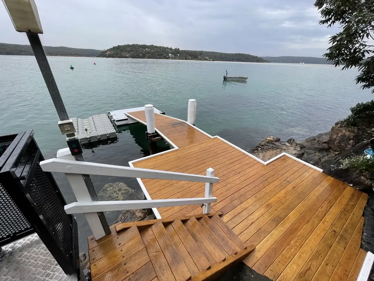 Freshly oiled hardwood deck and white handrail where the jetty meets the landing
