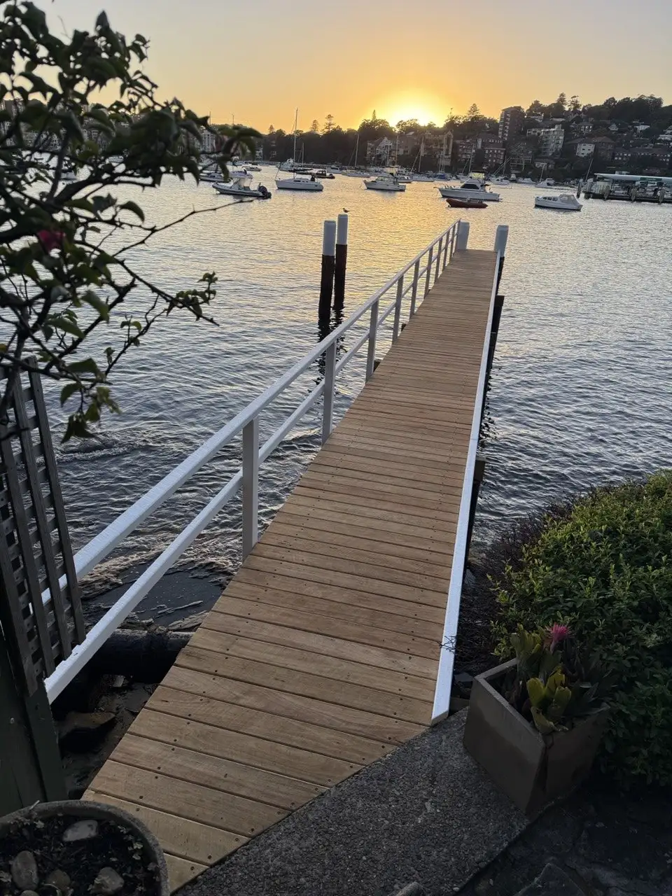 Jetty and handrail silhouetted against the bay at sunset