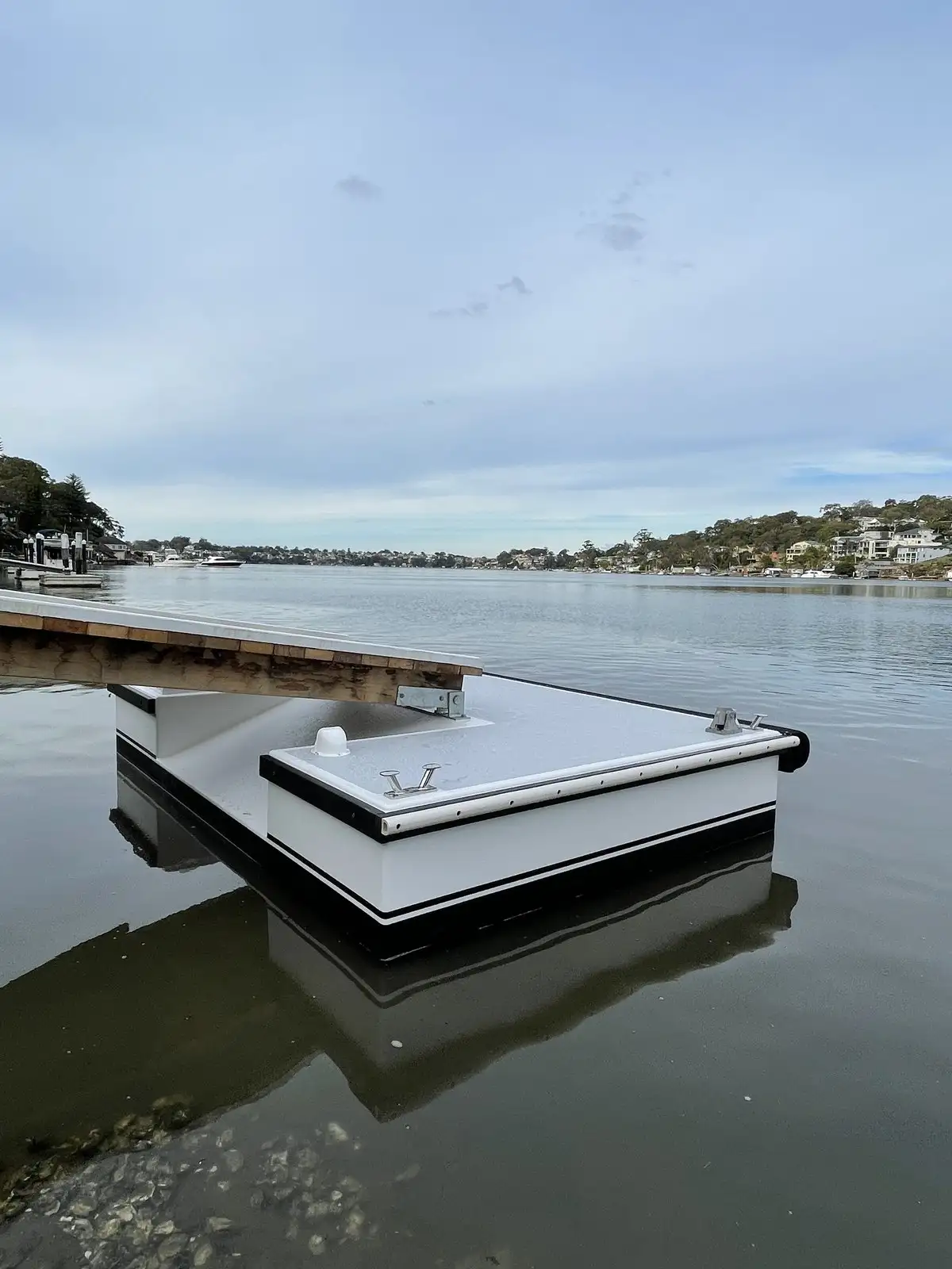 A pontoon and gangway on still water at dusk