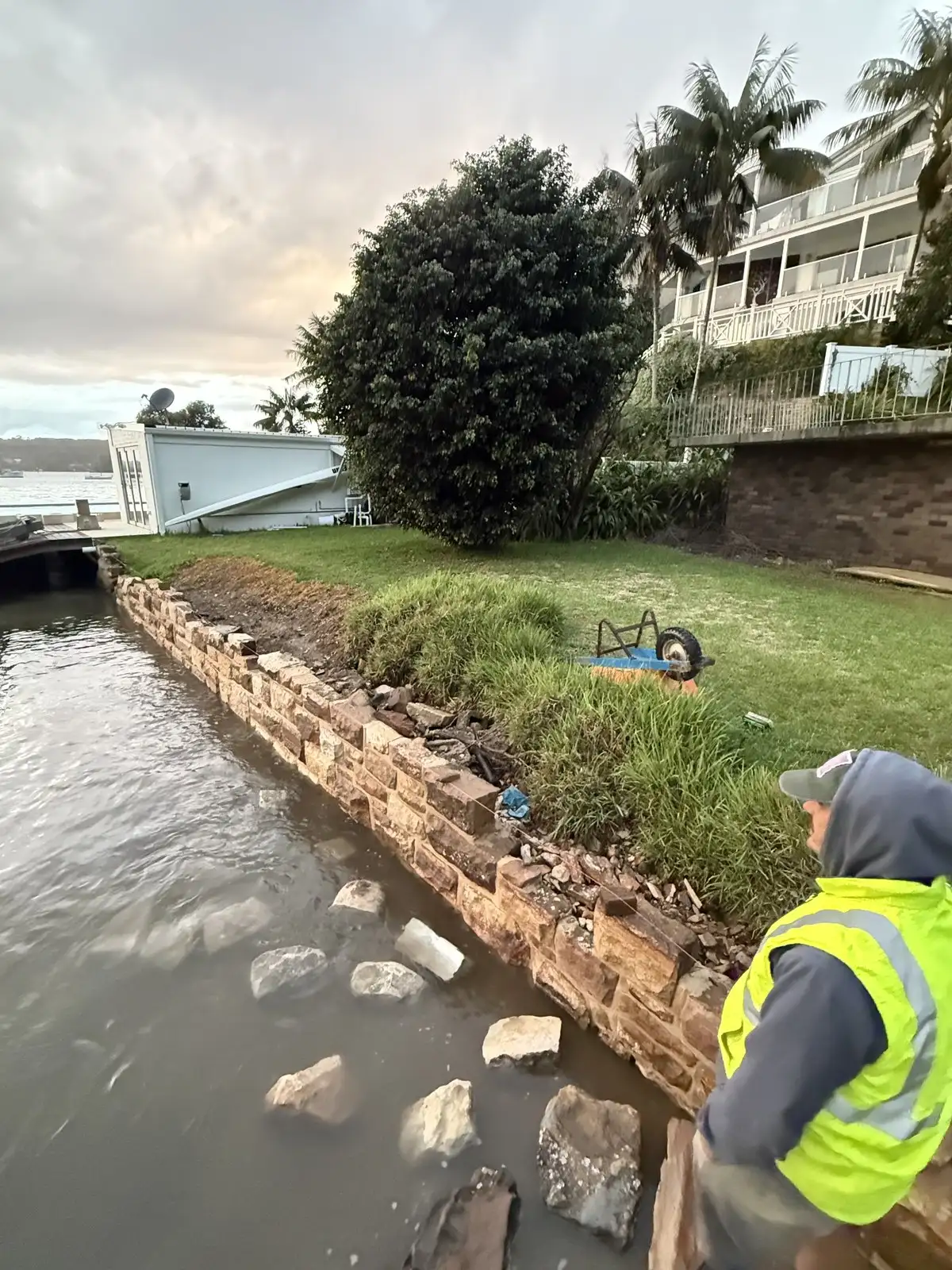 Crew in hi-vis rebuilding a stone foreshore wall from the water