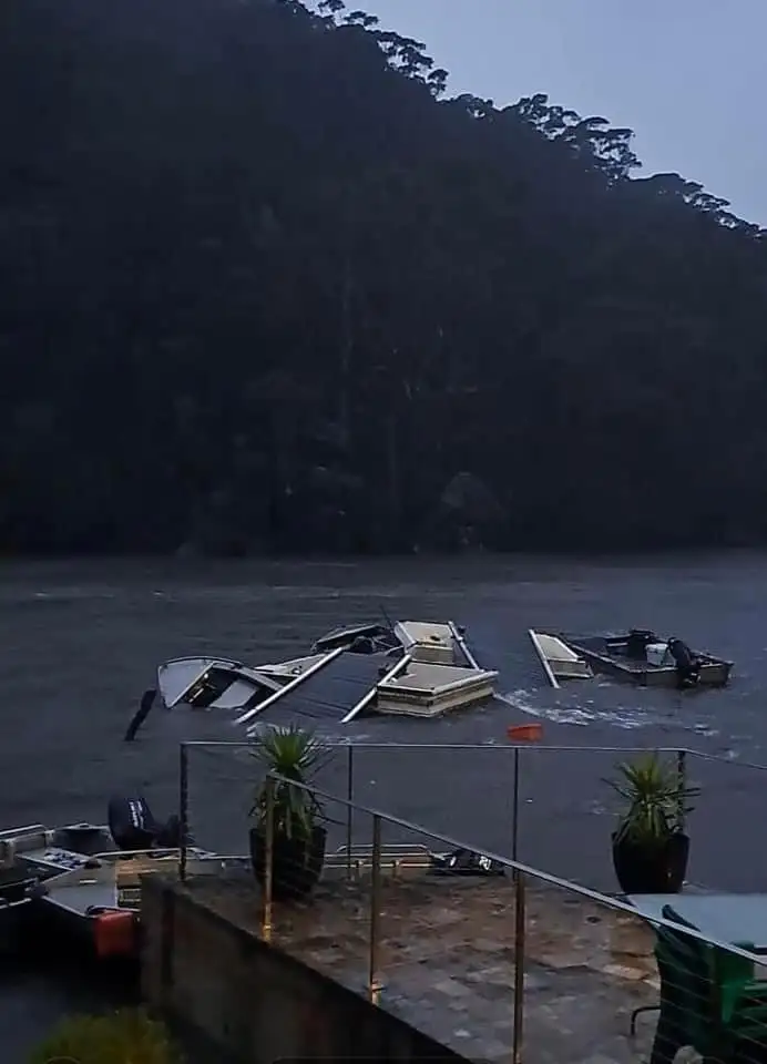 Storm-damaged pontoon and jetty photographed in low light