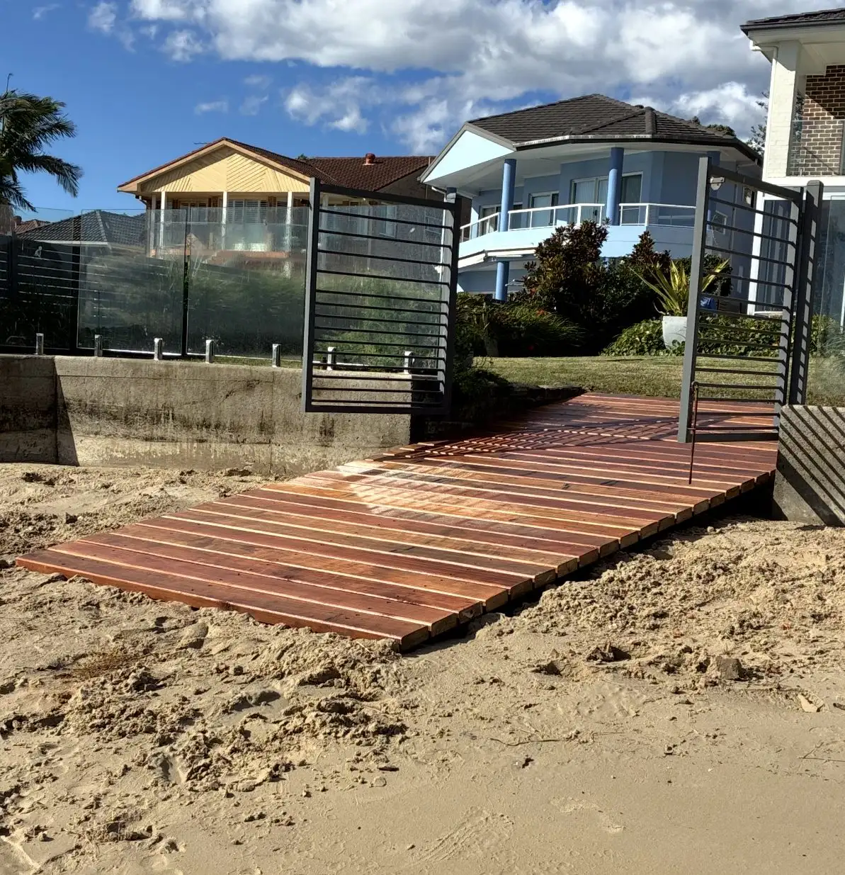 Completed turpentine skid ramp crossing the sand from a seawall gate down towards the water
