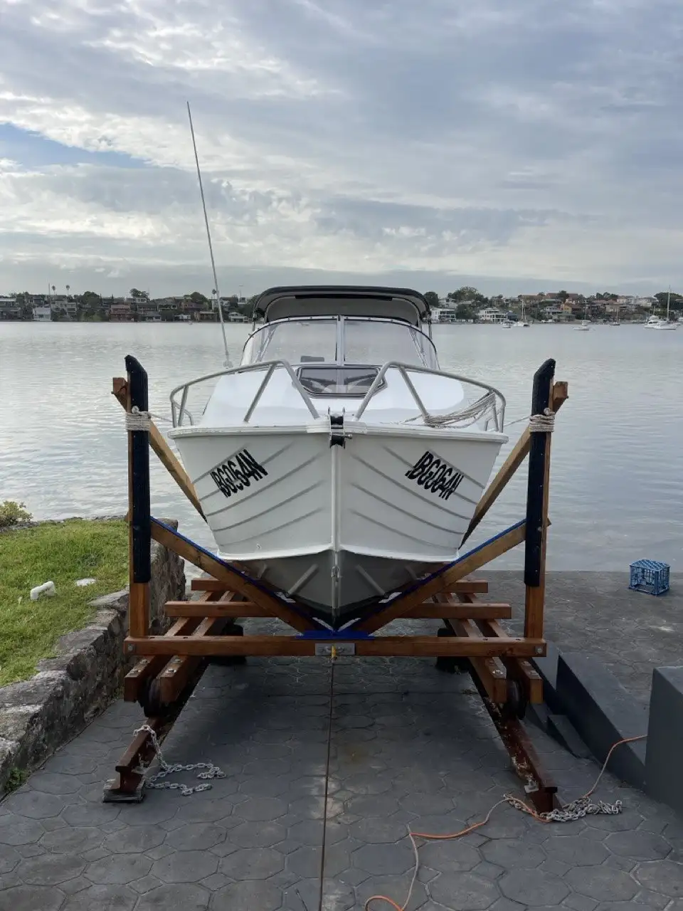 A boat on its cradle at the head of a concrete slipway ramp