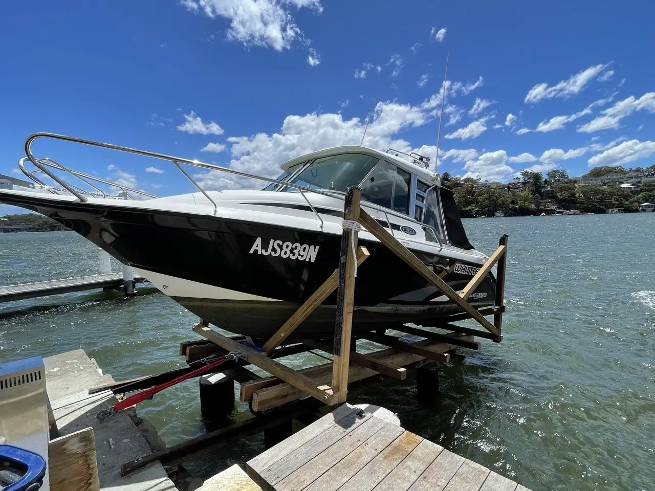 A boat sitting high on its cradle at the top of the slipway