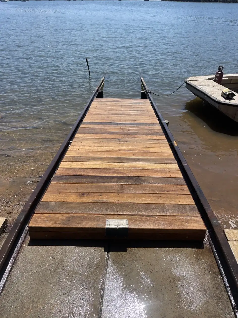 Timber slipway decking and rails running down into the water