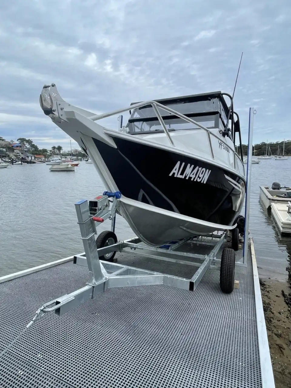 An aluminium runabout on a galvanised cradle at the top of the rails