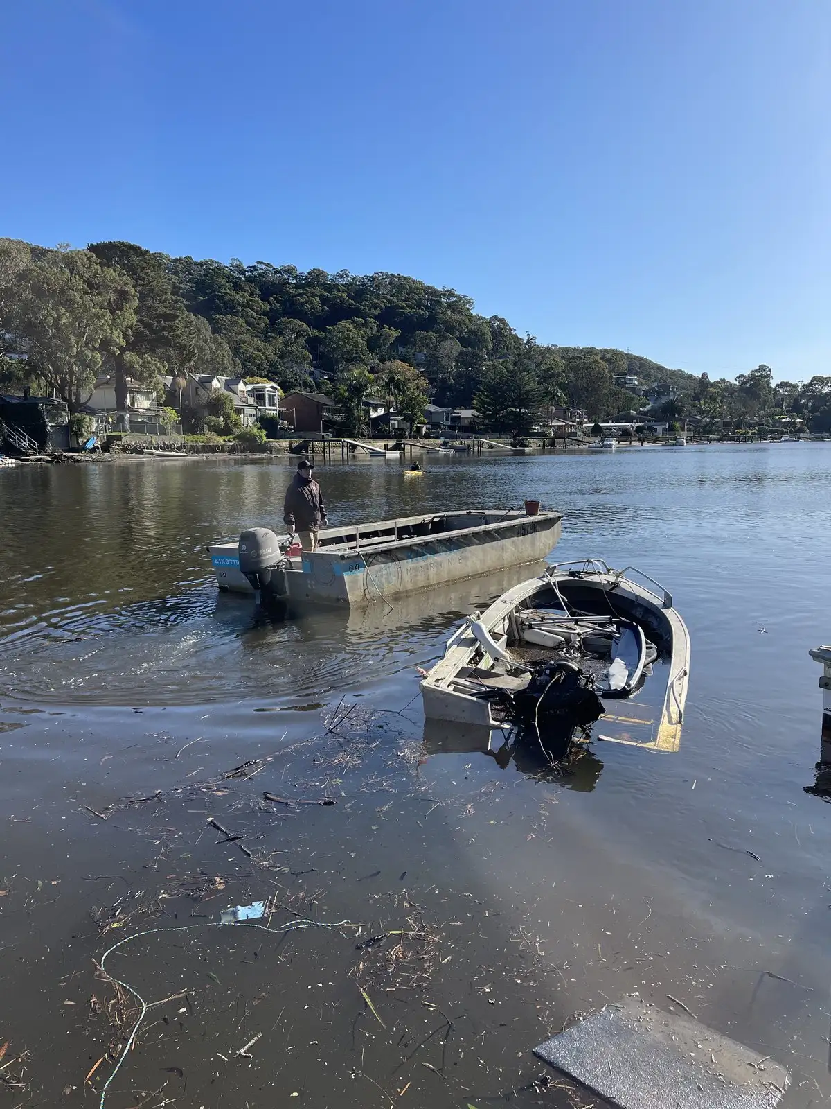 Storm debris being lifted out of the water into the work boat